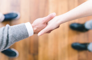 A supplier shaking hands with a property manager after the completion of a deal, thanks to smart apartment data software.